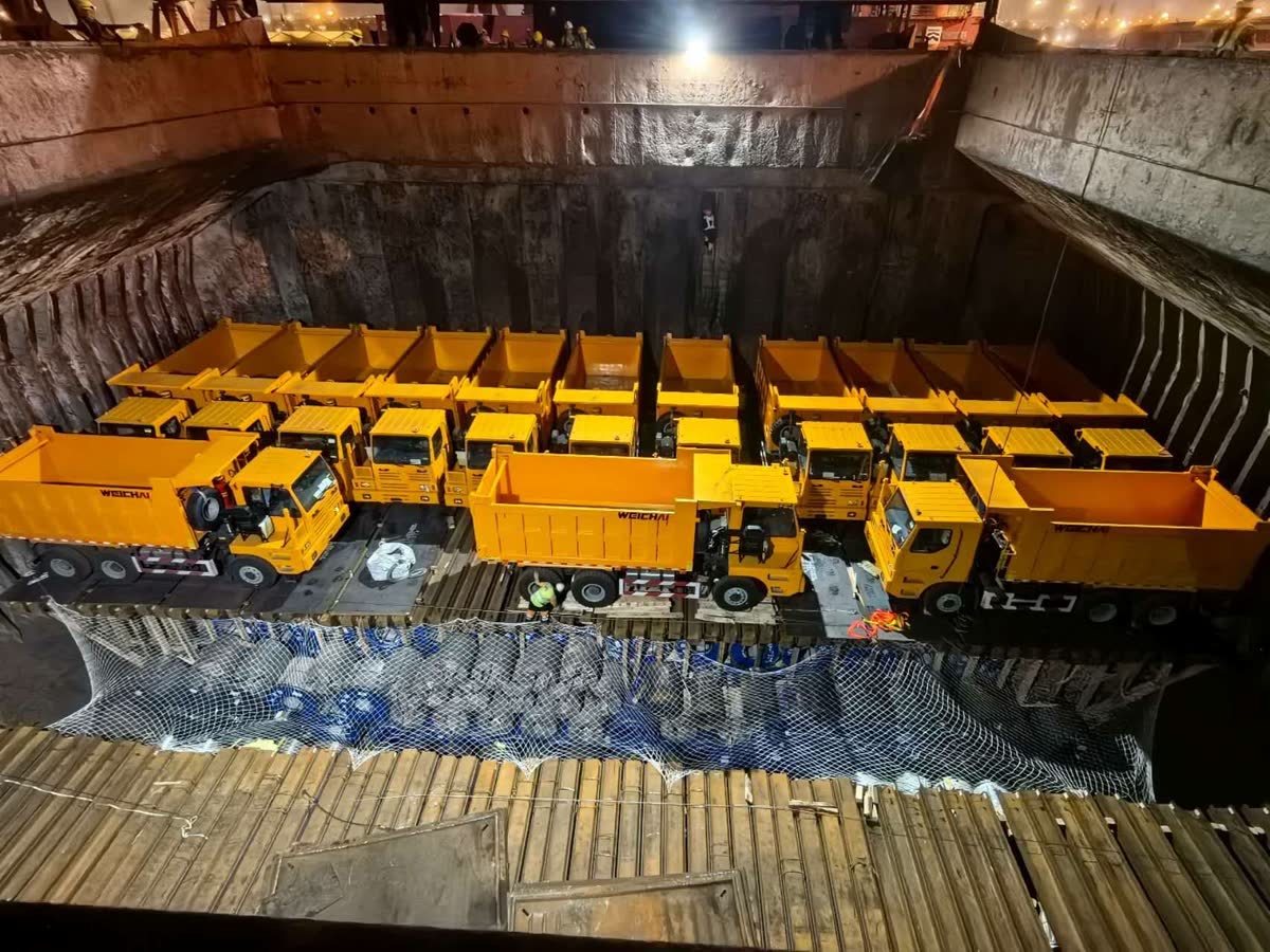 Dump trucks stowed in tiers inside a vessel hold